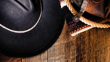 black cowboy hat with boots, spurs and rope