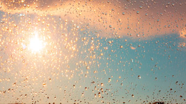 sun shining through a window, wet from rain