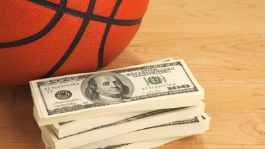 Basketball and stack of 100s on basketball court