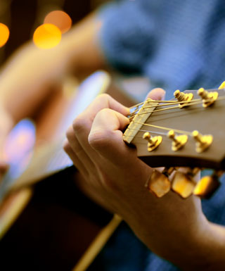 A close-up of someone playing guitar.
